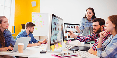 Businessman-showing-computer-screen-to-coworkers-in-creative-office-2